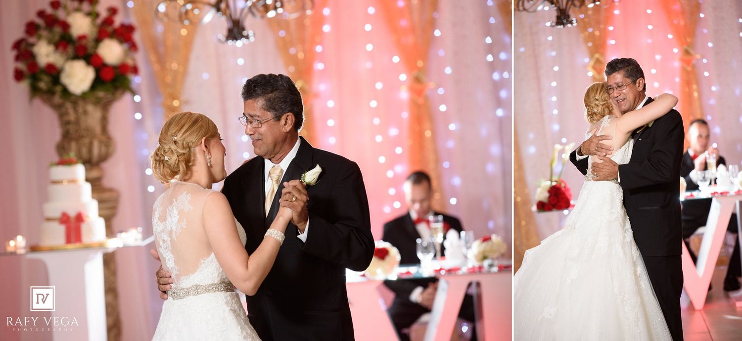 Bride and groom share their first dance at a romantic wedding reception with warm lights and red floral decor.