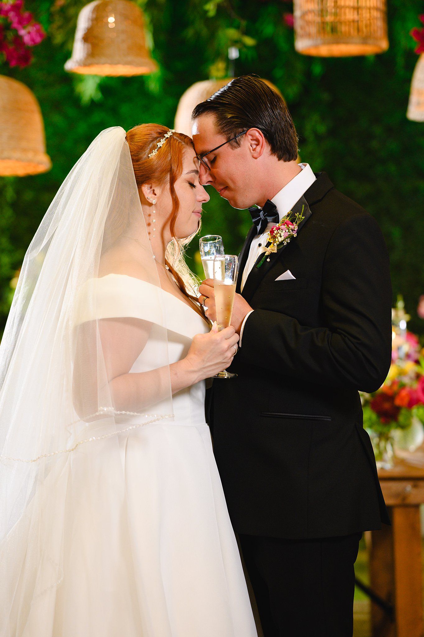 Bride and groom share an intimate moment holding champagne glasses at their elegant wedding ceremony.