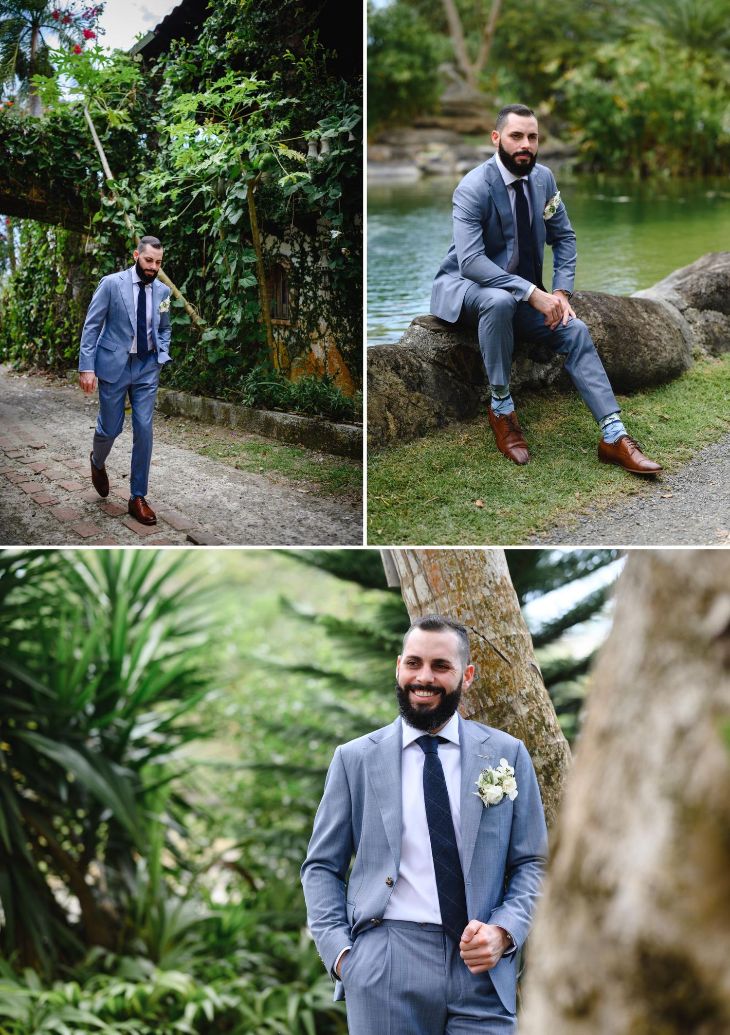 Handsome groom in a light gray suit with dark tie and brown shoes posing outdoors in a lush tropical garden setting.