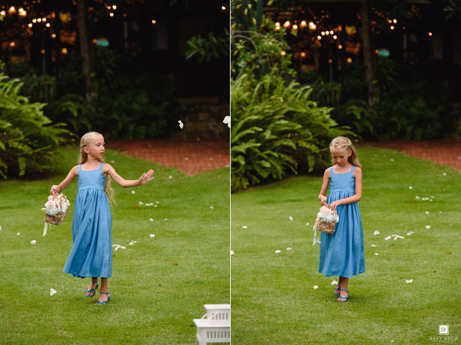 A young flower girl in a blue dress scatters white petals on a lush green lawn at an outdoor wedding ceremony.