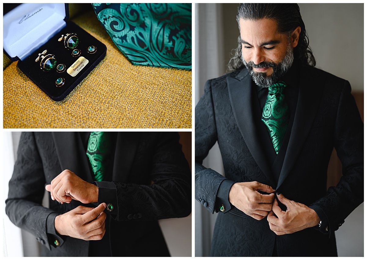Groom in dark suit with emerald green tie and cufflinks, adjusting jacket buttons on wedding day.