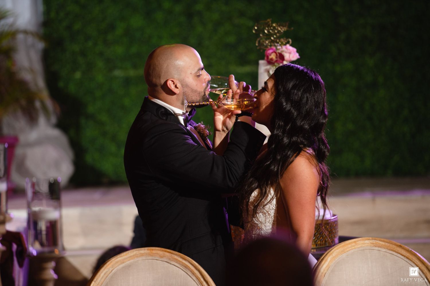 Bride and groom share a drink together during their wedding reception celebration.