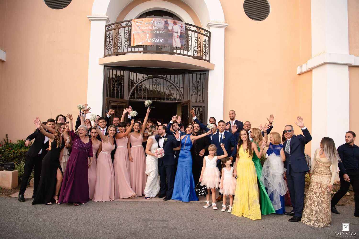 Wedding party and guests celebrating outside a church after the ceremony.