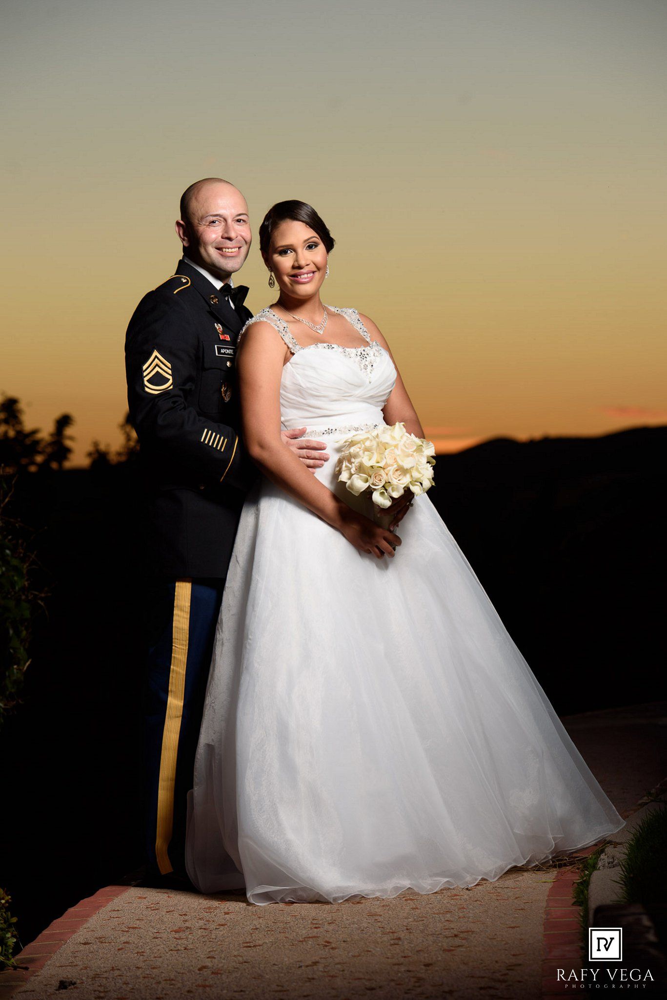 Military groom and bride posing at sunset wedding portrait.