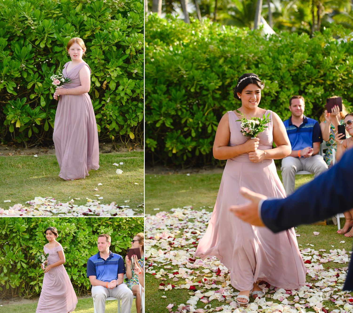 Bridesmaids in dusty rose gowns walk down a flower-petal aisle at an outdoor tropical wedding ceremony.