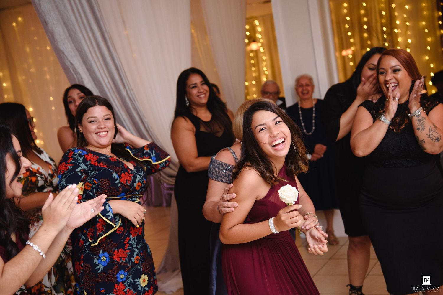 Joyful wedding guests dancing and celebrating on the dance floor during a lively wedding reception.