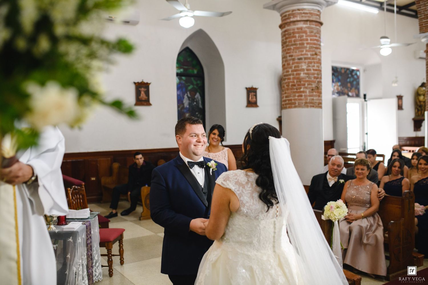Bride and groom share a joyful moment at the altar during their church wedding ceremony.