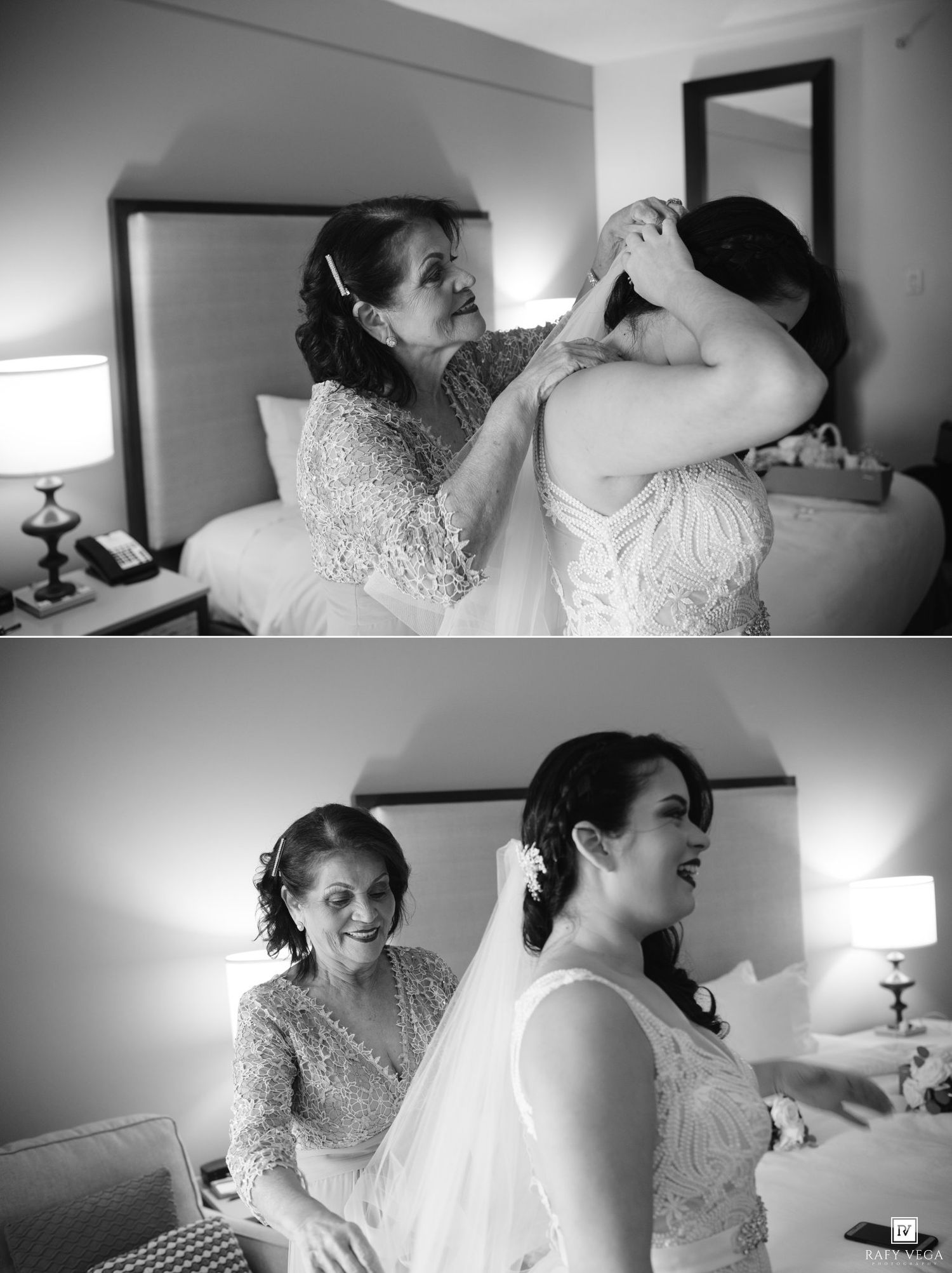 Black and white photo of a mother helping her daughter into a wedding dress in a hotel room.