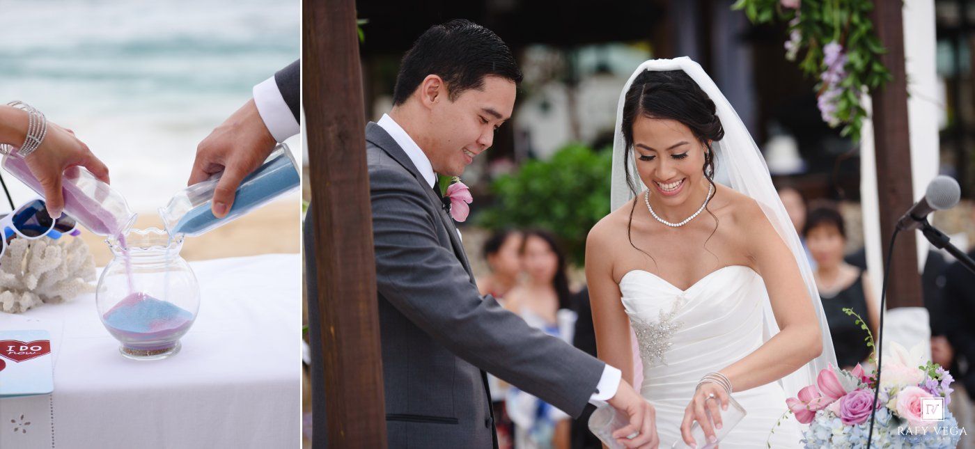 A bride and groom participate in a sand unity ceremony at an outdoor beach wedding, smiling joyfully.