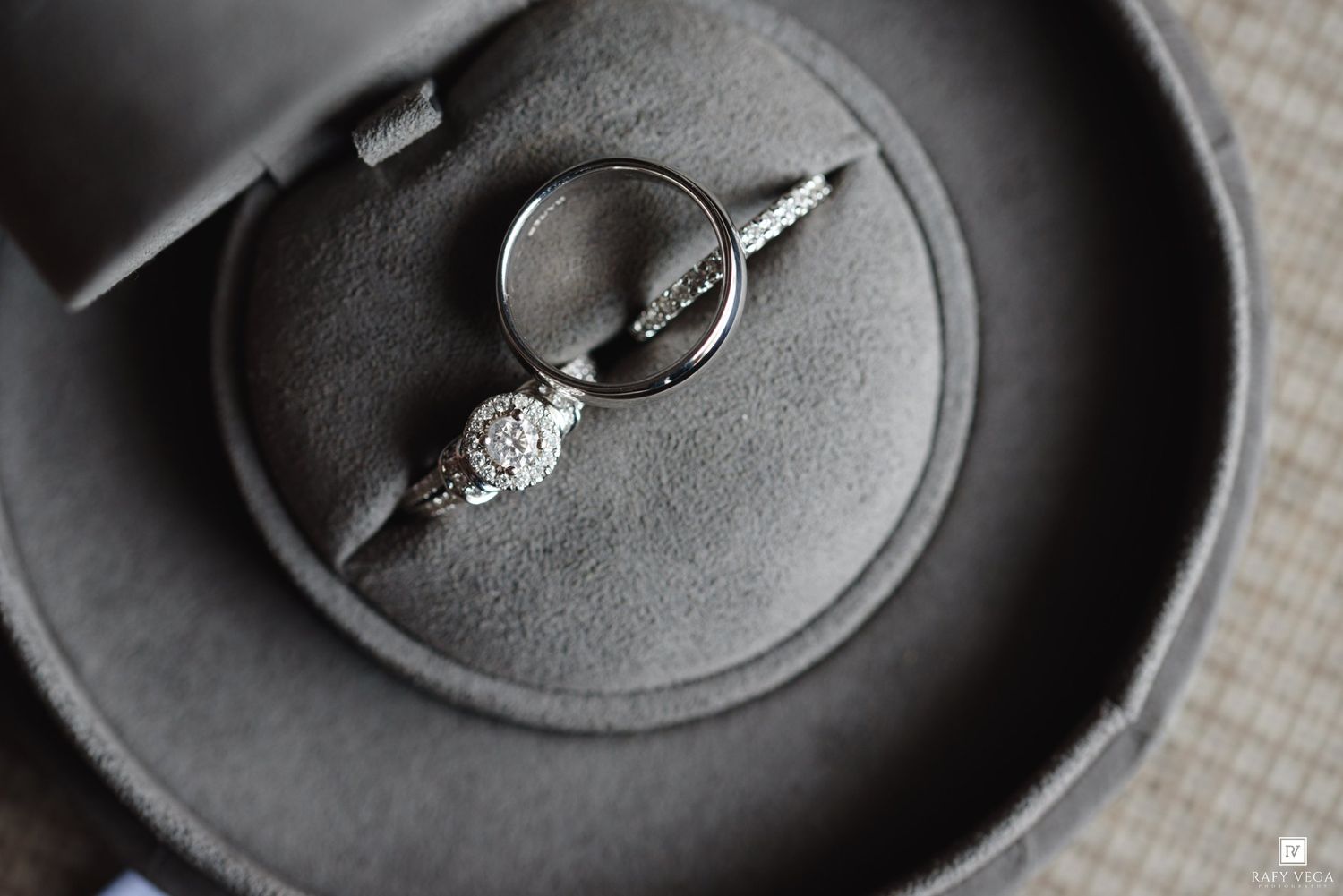 Silver engagement ring with diamond accents displayed in a gray velvet ring box, elegant jewelry photography.