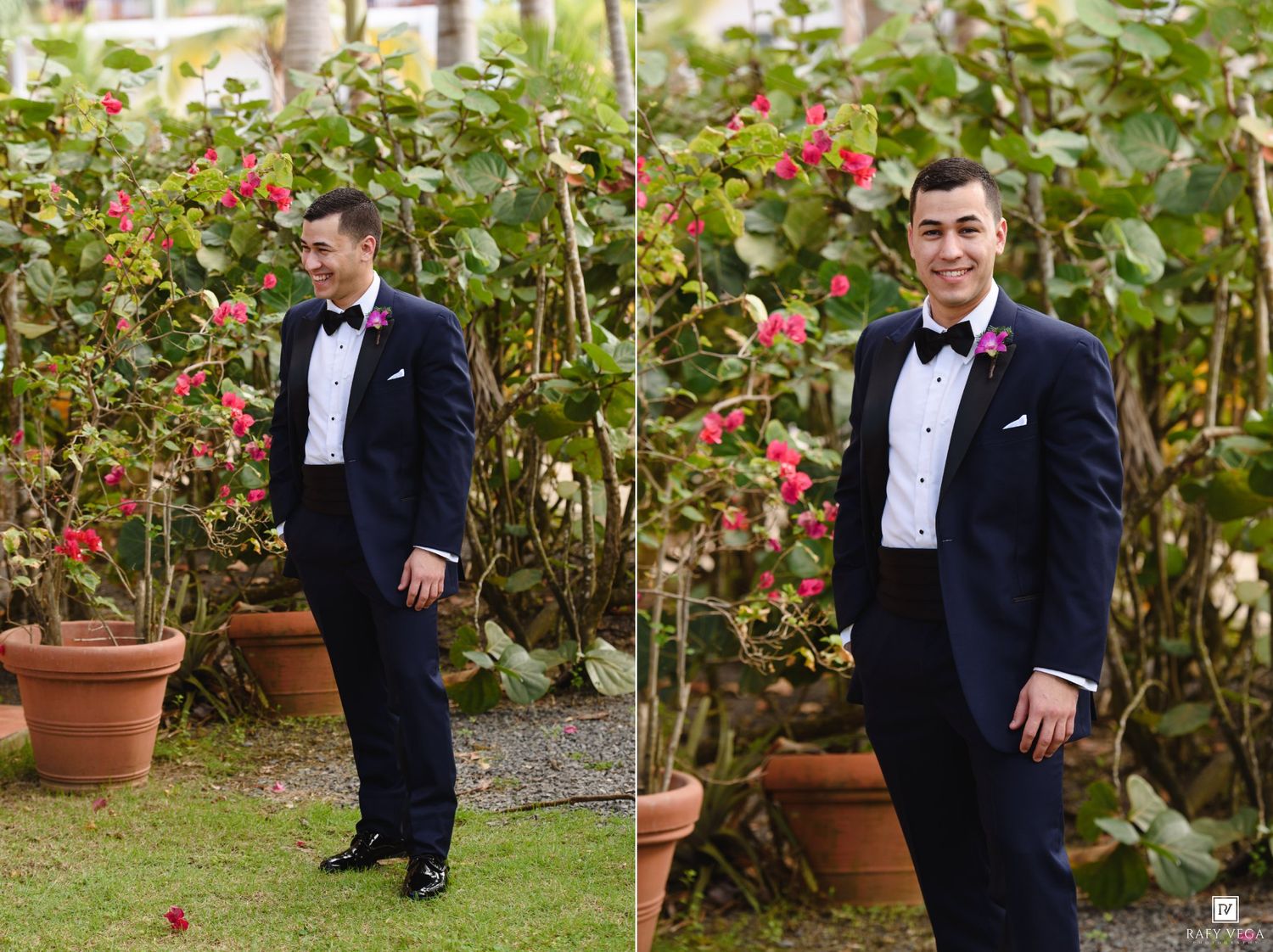 Dapper groom in navy tuxedo with pink boutonniere smiling in garden with vibrant bougainvillea flowers.