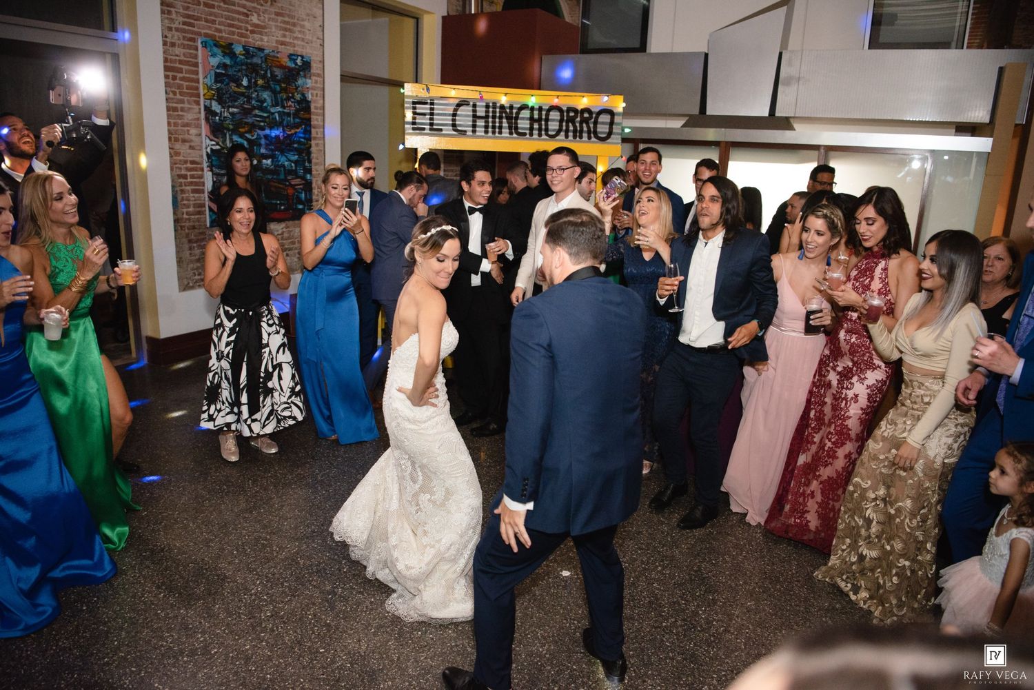 Bride and groom share first dance surrounded by elegantly dressed guests at El Chinchorro wedding reception.