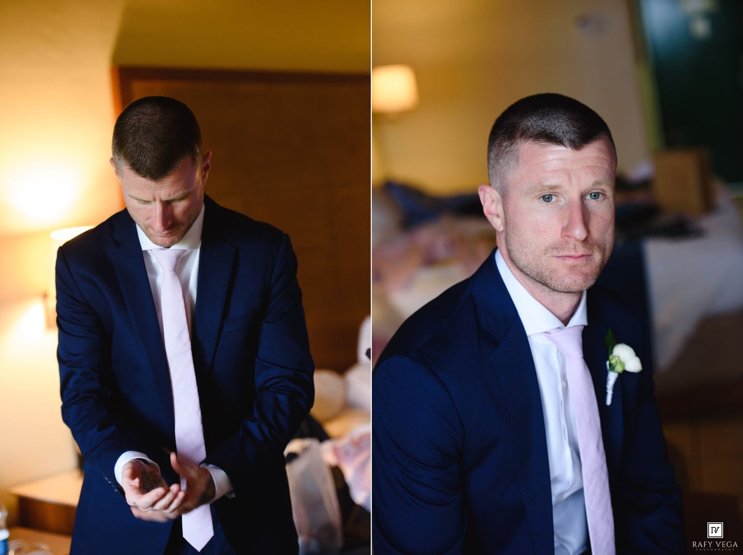 Groom in navy suit and white tie checks phone before wedding ceremony, boutonniere visible in close-up portrait.