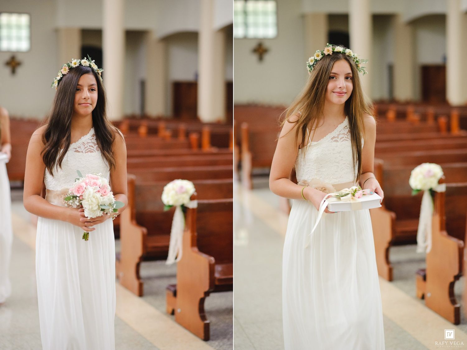 Two bridesmaids in white dresses and floral crowns stand in a church aisle, one holding a bouquet and one holding a book.