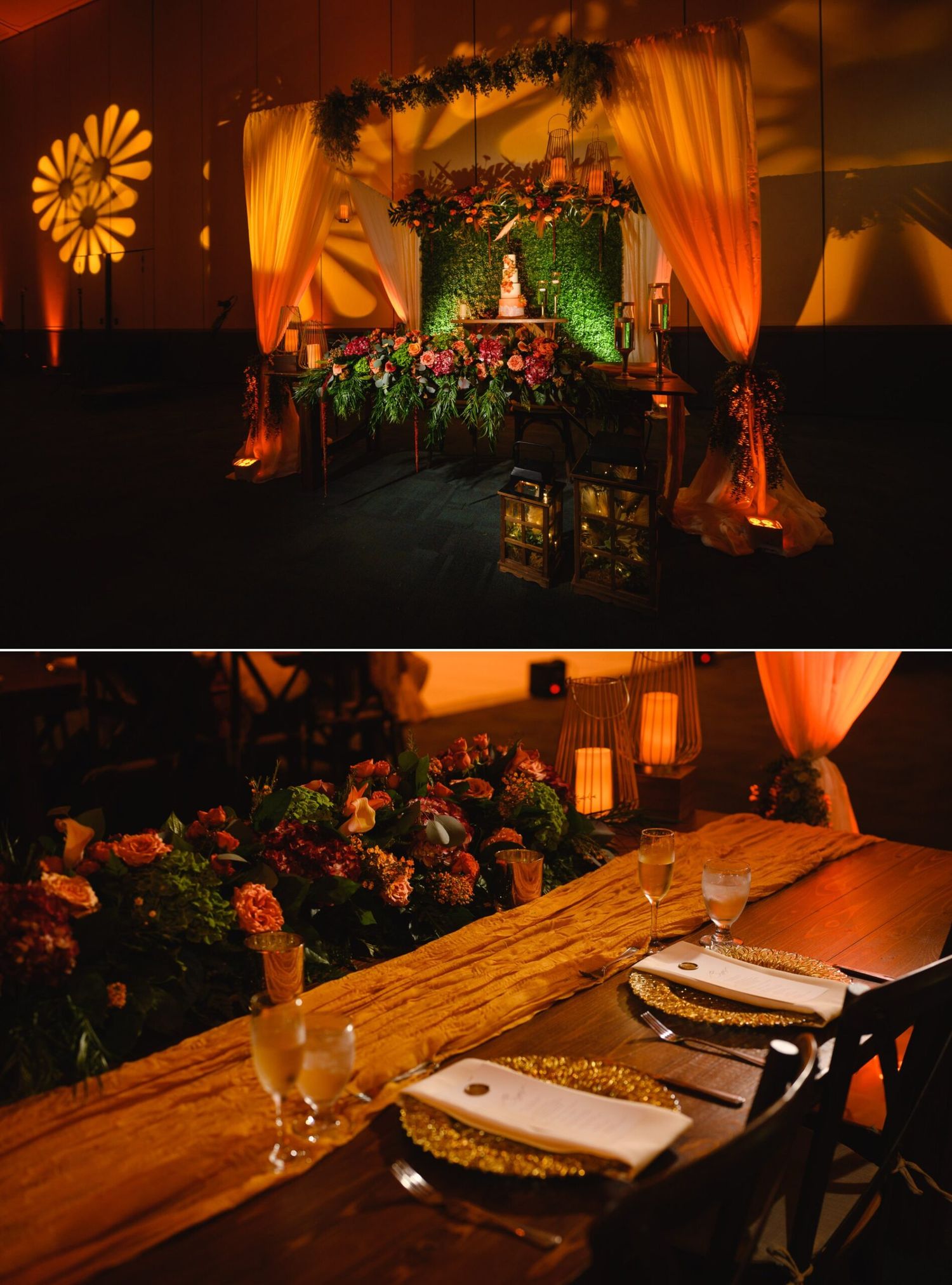 Elegant wedding reception with floral arch backdrop, cake table, warm amber lighting, and rustic wood dining table with gold charger plates.