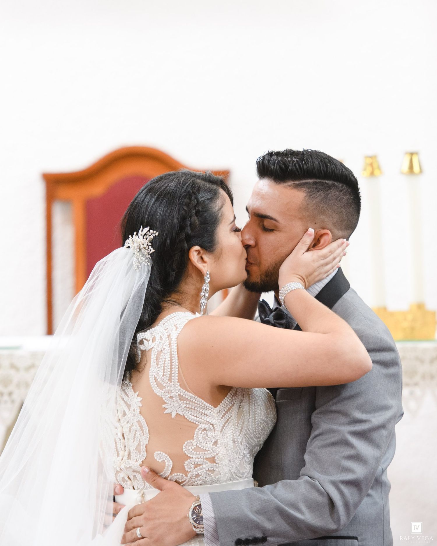 Bride and groom share their first kiss at the altar during a romantic church wedding ceremony.