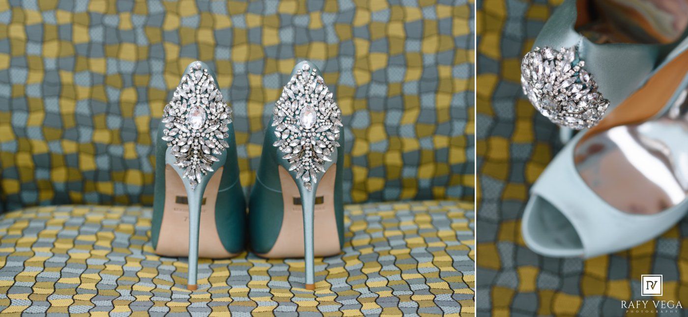 Elegant silver bridal heels with ornate crystal embellishments on the sole and heel, displayed on a patterned surface.