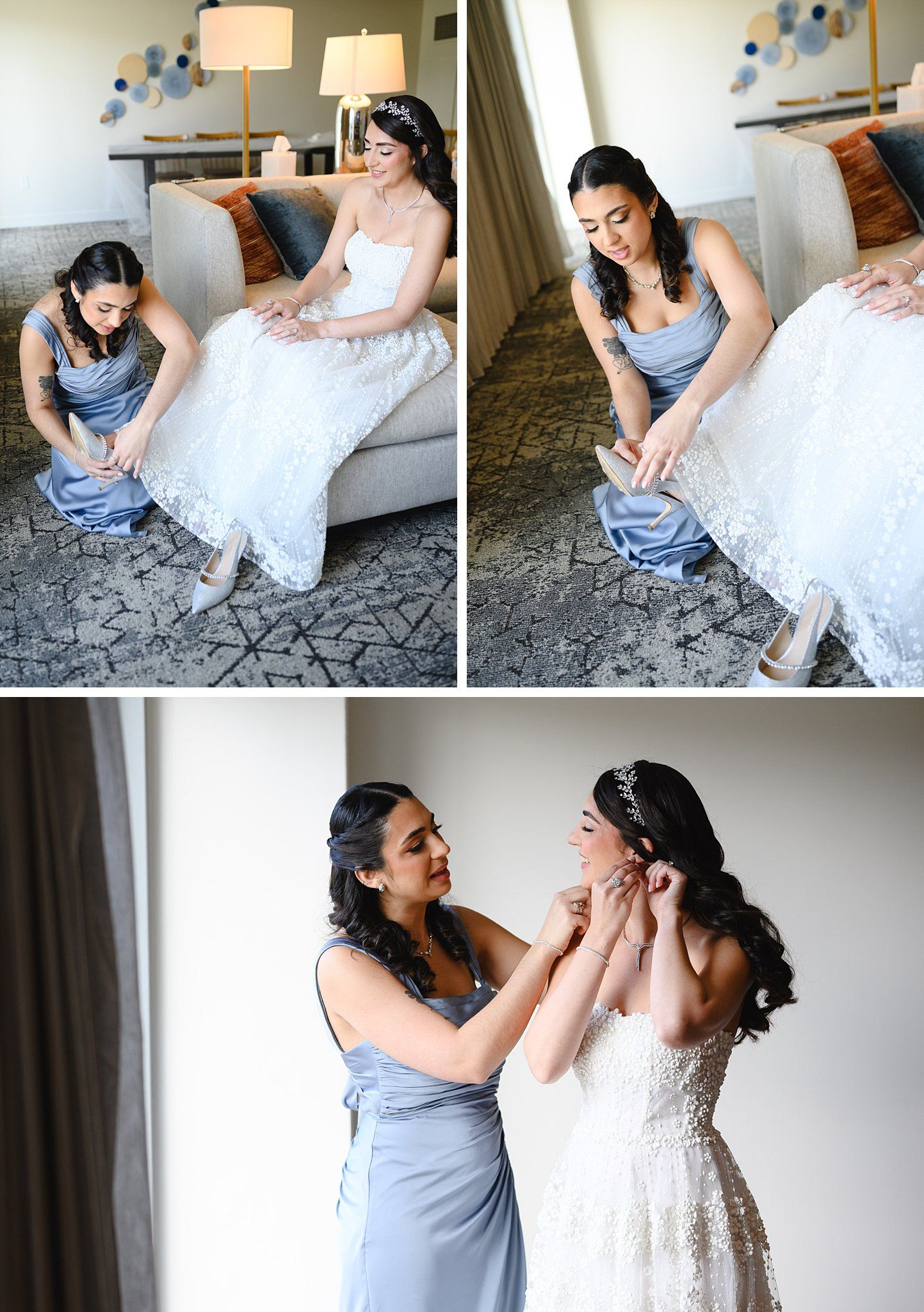 Bridesmaid in blue dress helps bride with shoes and dress buttons while getting ready in a hotel room.
