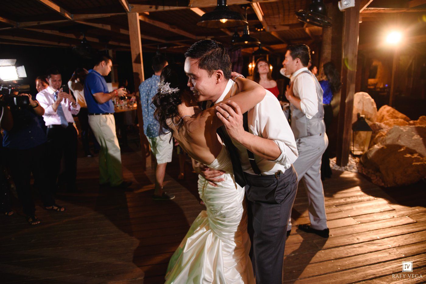 Bride and groom share a romantic first dance kiss at their wedding reception.