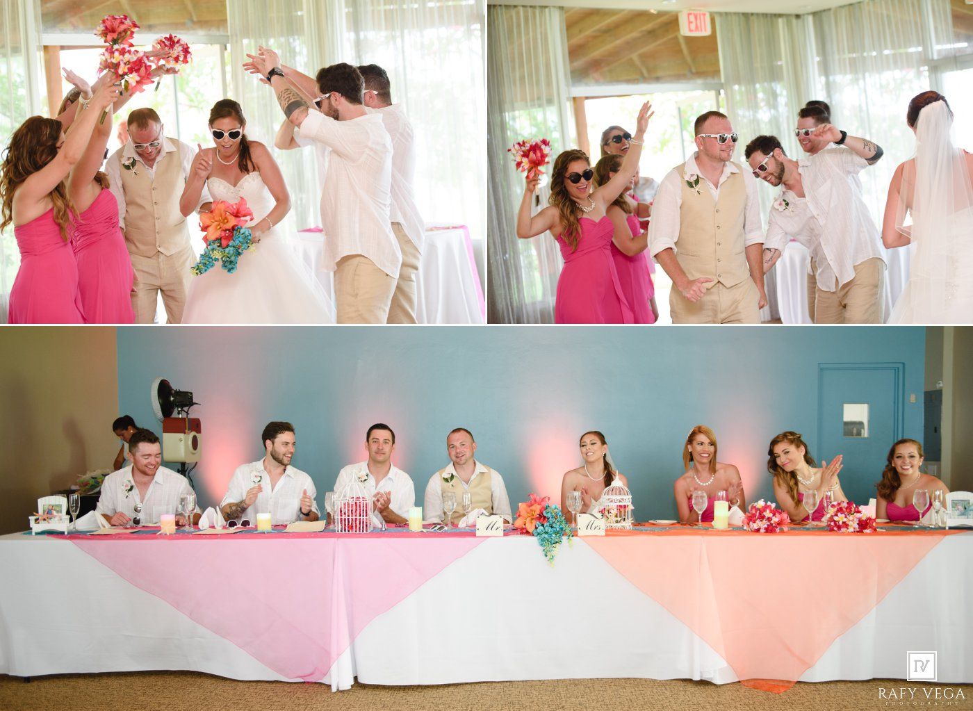 Wedding party celebrates in pink and white reception hall, bridal party in pink dresses and khaki suits at head table.