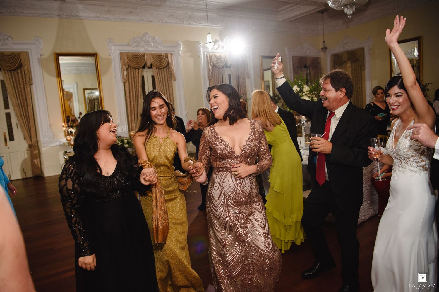 Guests celebrate and dance joyfully at a lively wedding reception party.