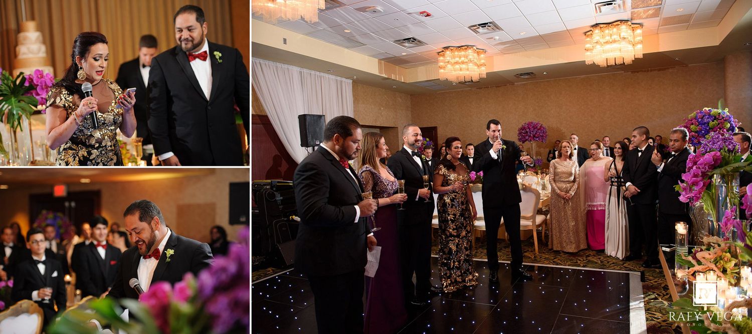 Elegant wedding reception with couple cutting cake, guests celebrating, chandelier lighting, and purple floral decorations in a ballroom.