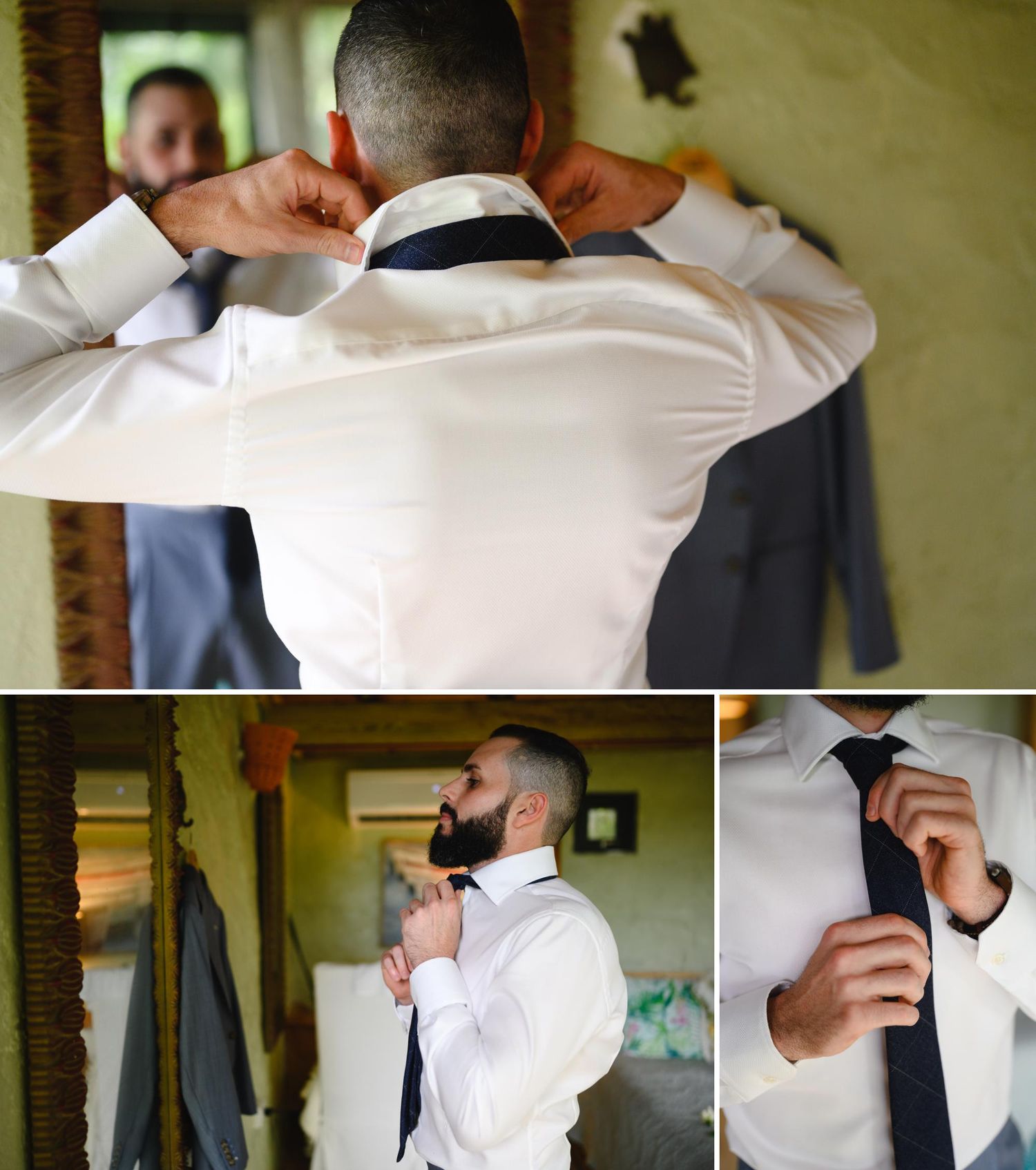 Groom getting dressed for wedding, adjusting collar and tie in white dress shirt with navy blue necktie.