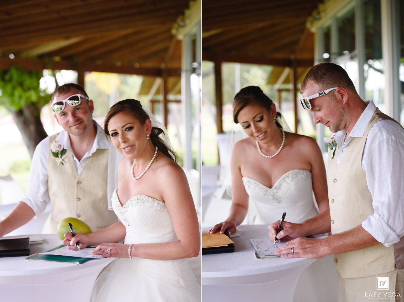 Bride and groom signing wedding registry documents at outdoor venue ceremony, bride in strapless gown, groom in tan suit.