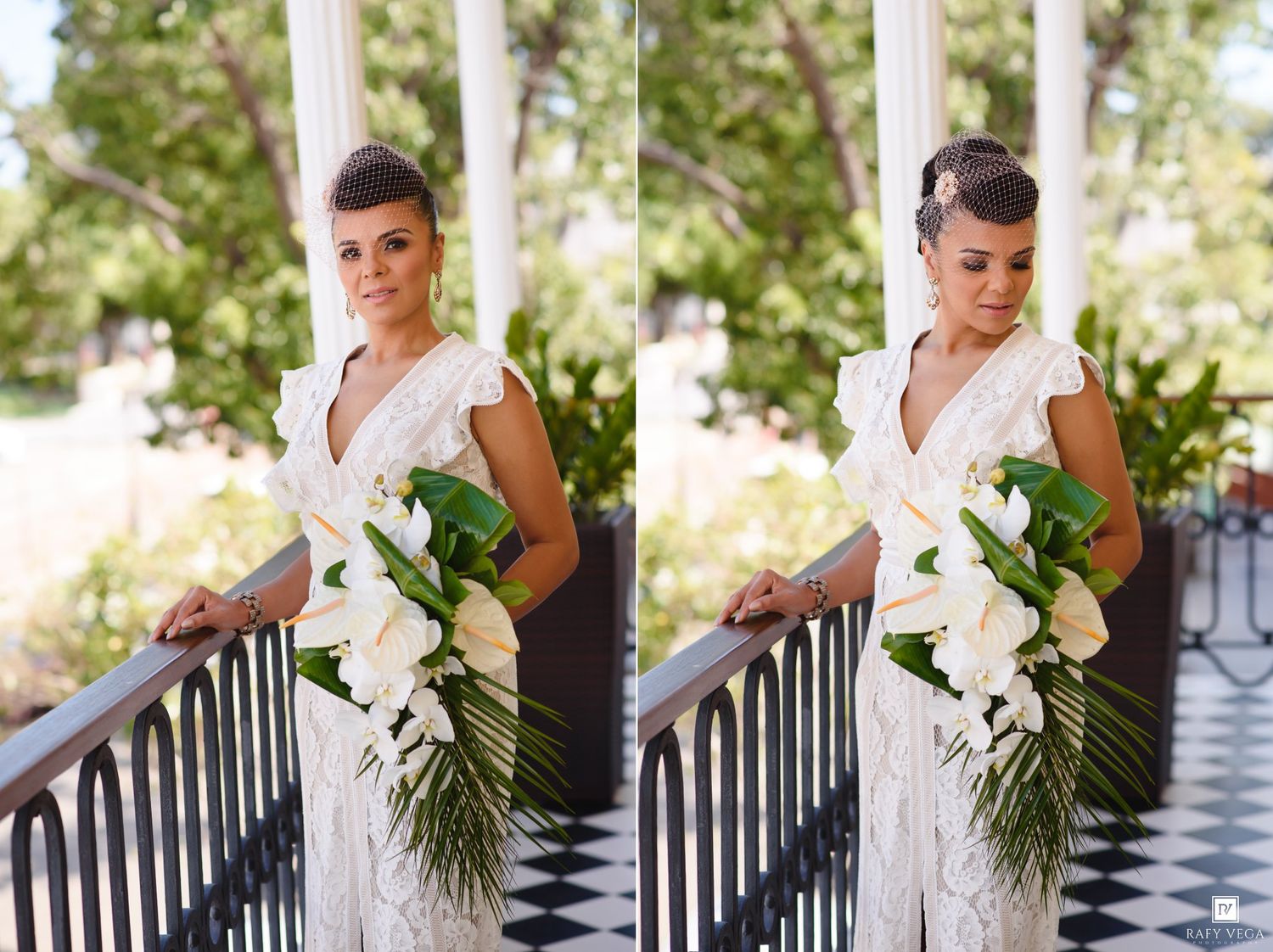 Bride in white lace gown holding tropical bouquet of calla lilies and palm leaves on elegant porch with columns.