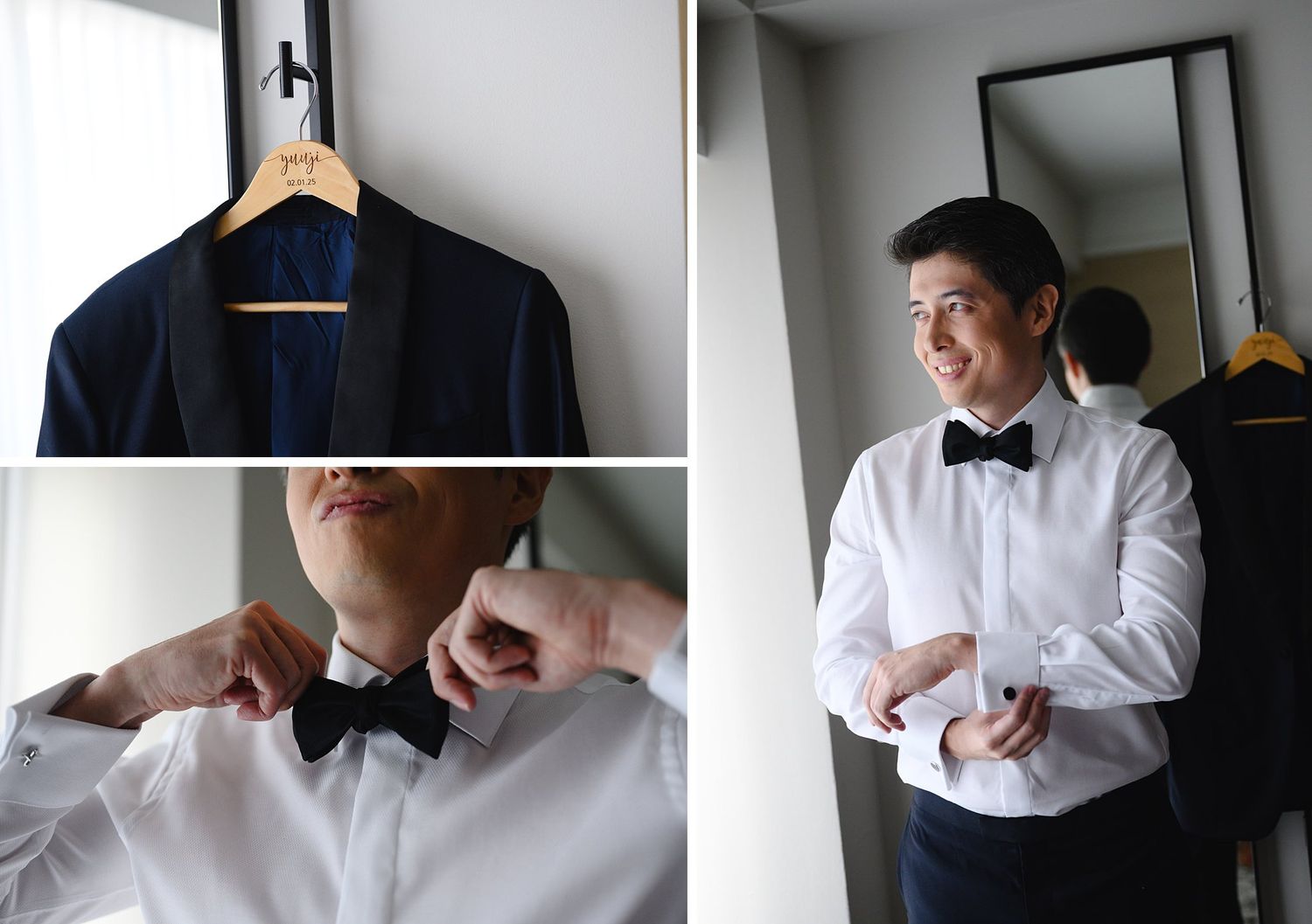 Groom getting ready in a white tuxedo shirt and black bow tie, with a navy suit jacket hanging on a wooden hanger nearby.