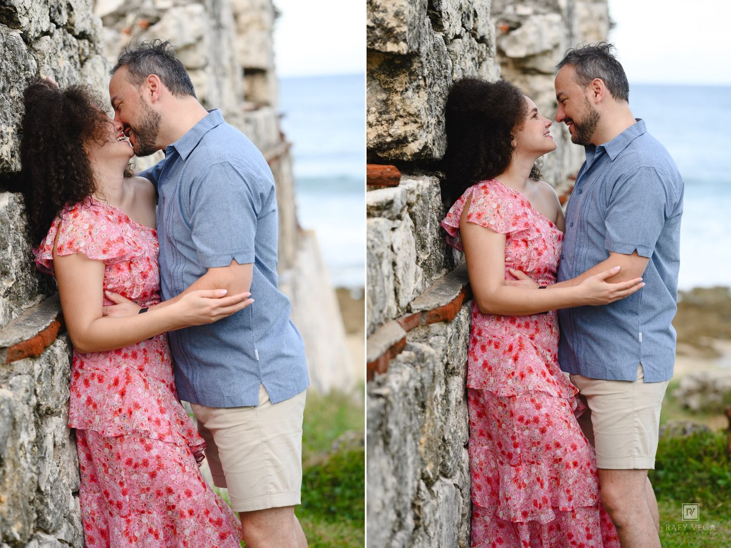Couple sharing a romantic kiss against a rustic stone wall with ocean views in a tropical outdoor setting.