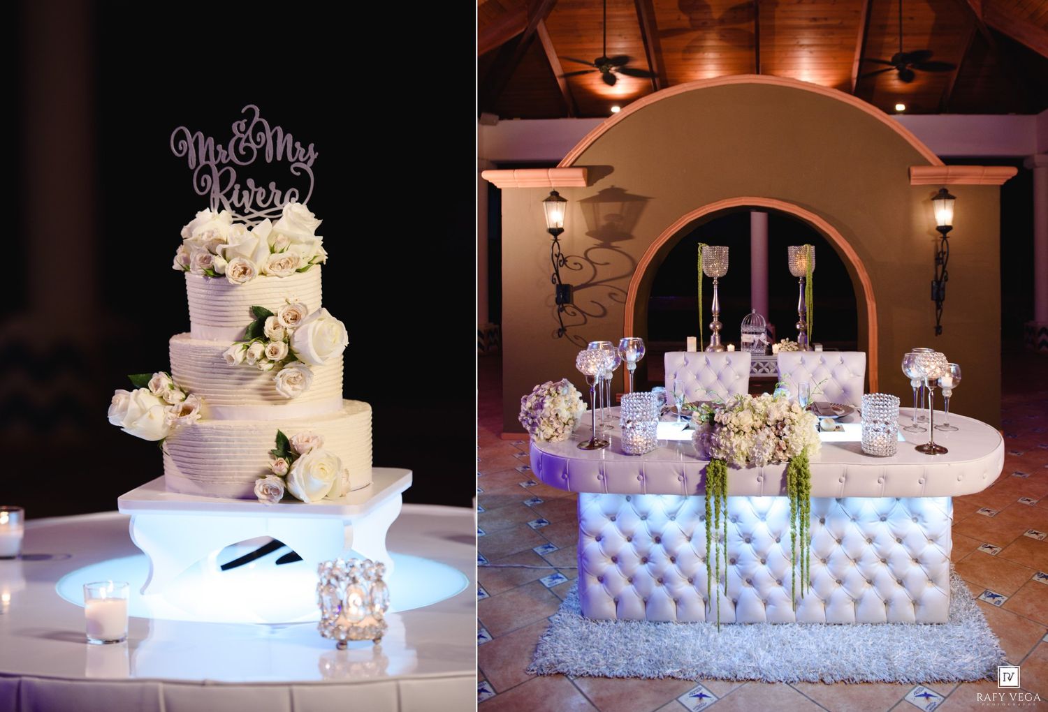 Elegant multi-tier white wedding cake with floral decor beside a tufted white sweetheart table with crystal accents.