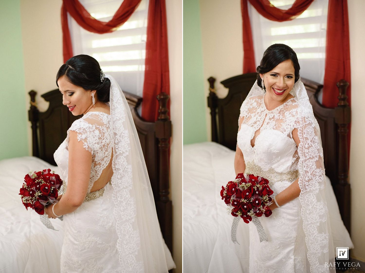 Bride in white lace wedding gown holding red rose bouquet with veil, posing elegantly in a decorated bedroom.