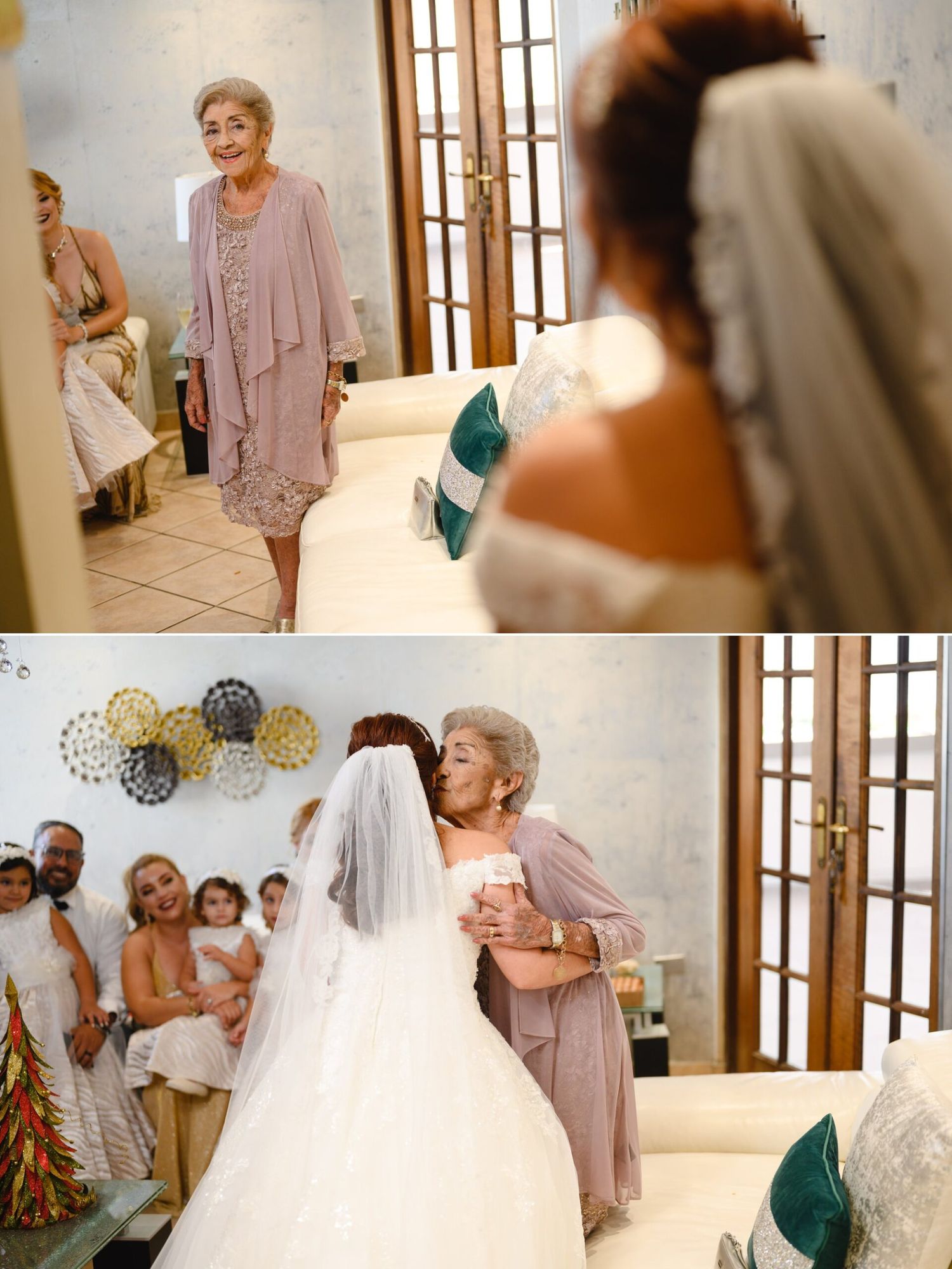 Elderly woman in pink dress shares emotional first look embrace with bride in white gown and veil at wedding venue.