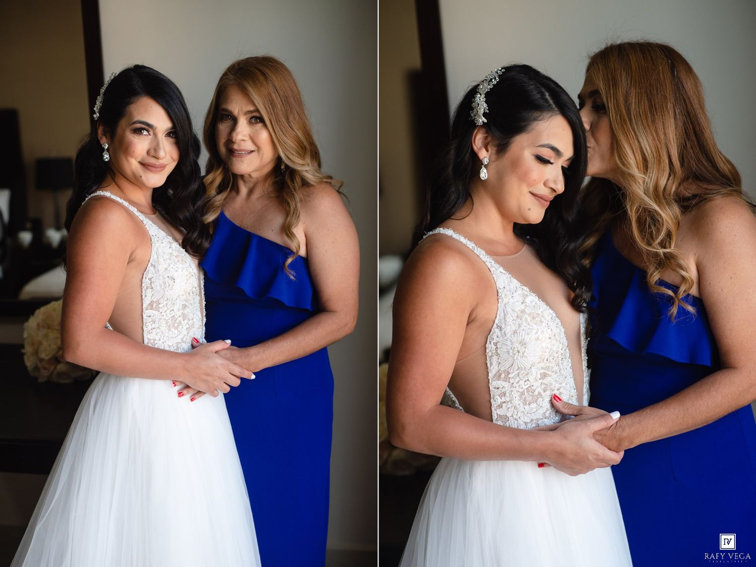 Bride in white lace gown with bridesmaid in royal blue dress sharing a tender moment during wedding preparations.