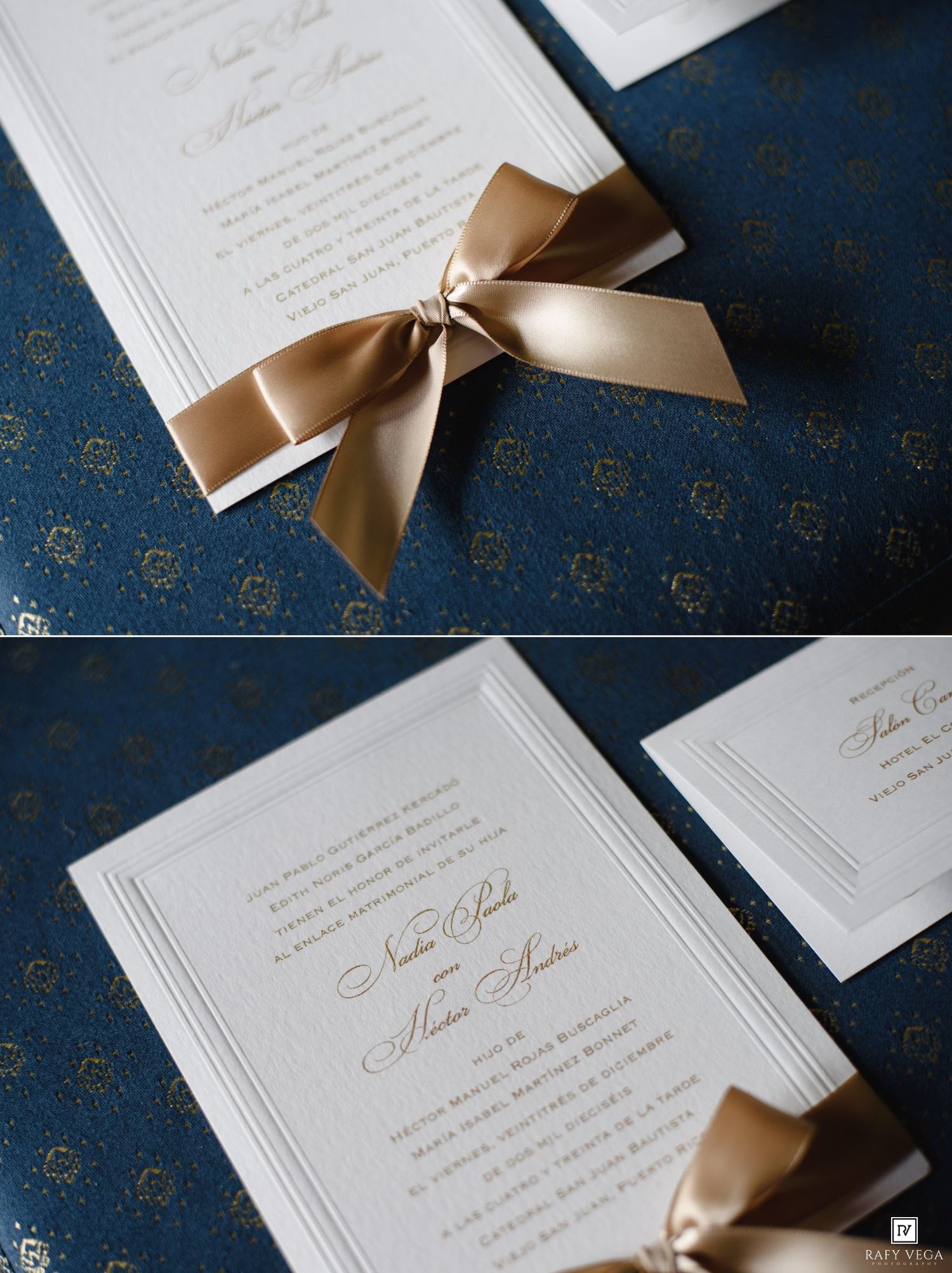 Elegant white wedding invitations with gold bow ribbon on navy blue damask background.