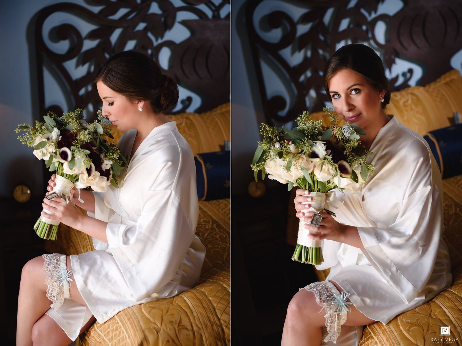 Bride in white satin robe holding elegant floral bouquet with roses and greenery while sitting on bed before wedding ceremony.
