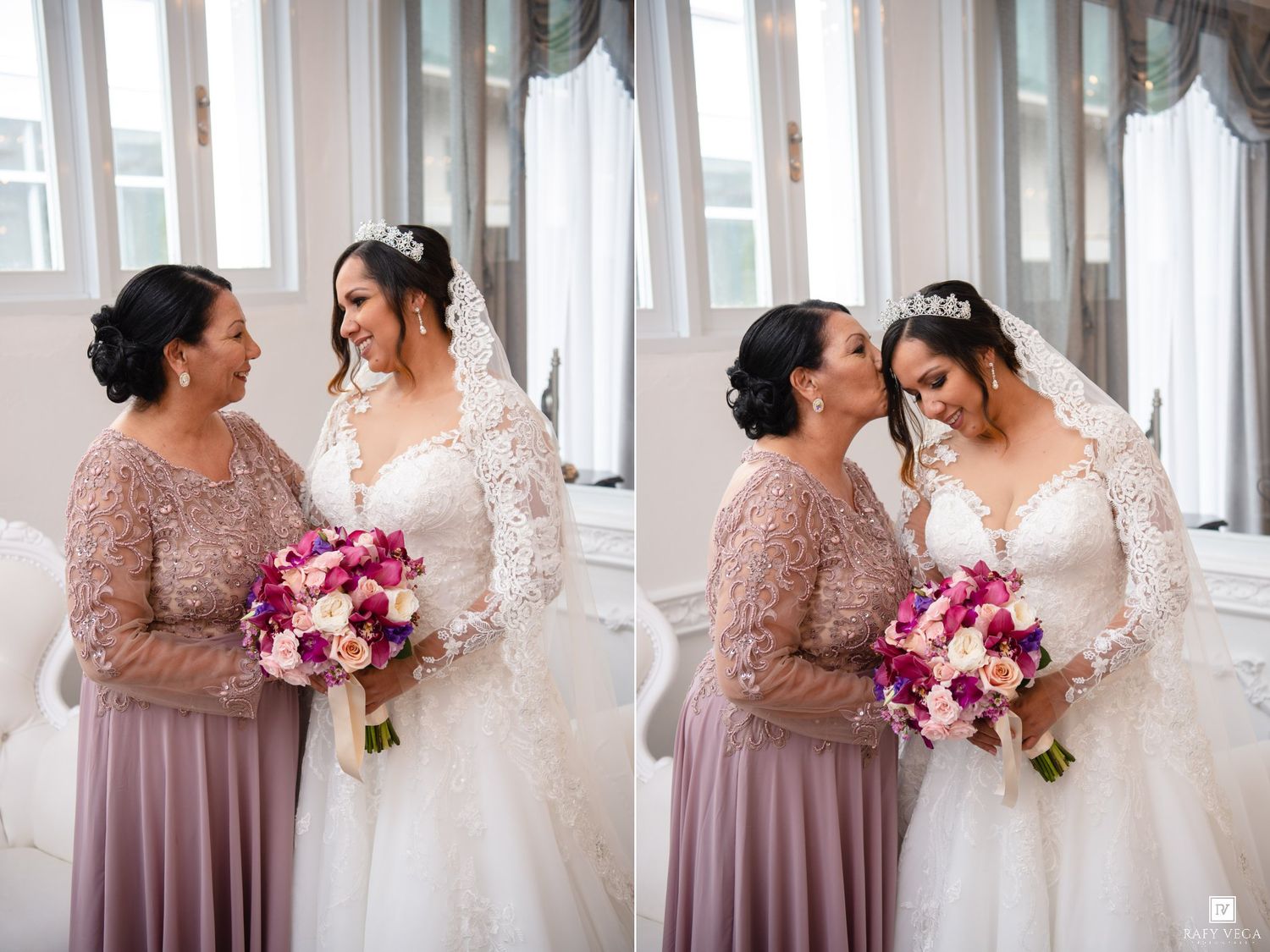 Bride in lace gown holding pink bouquet shares tender moment with mother in mauve dress during wedding day preparations.