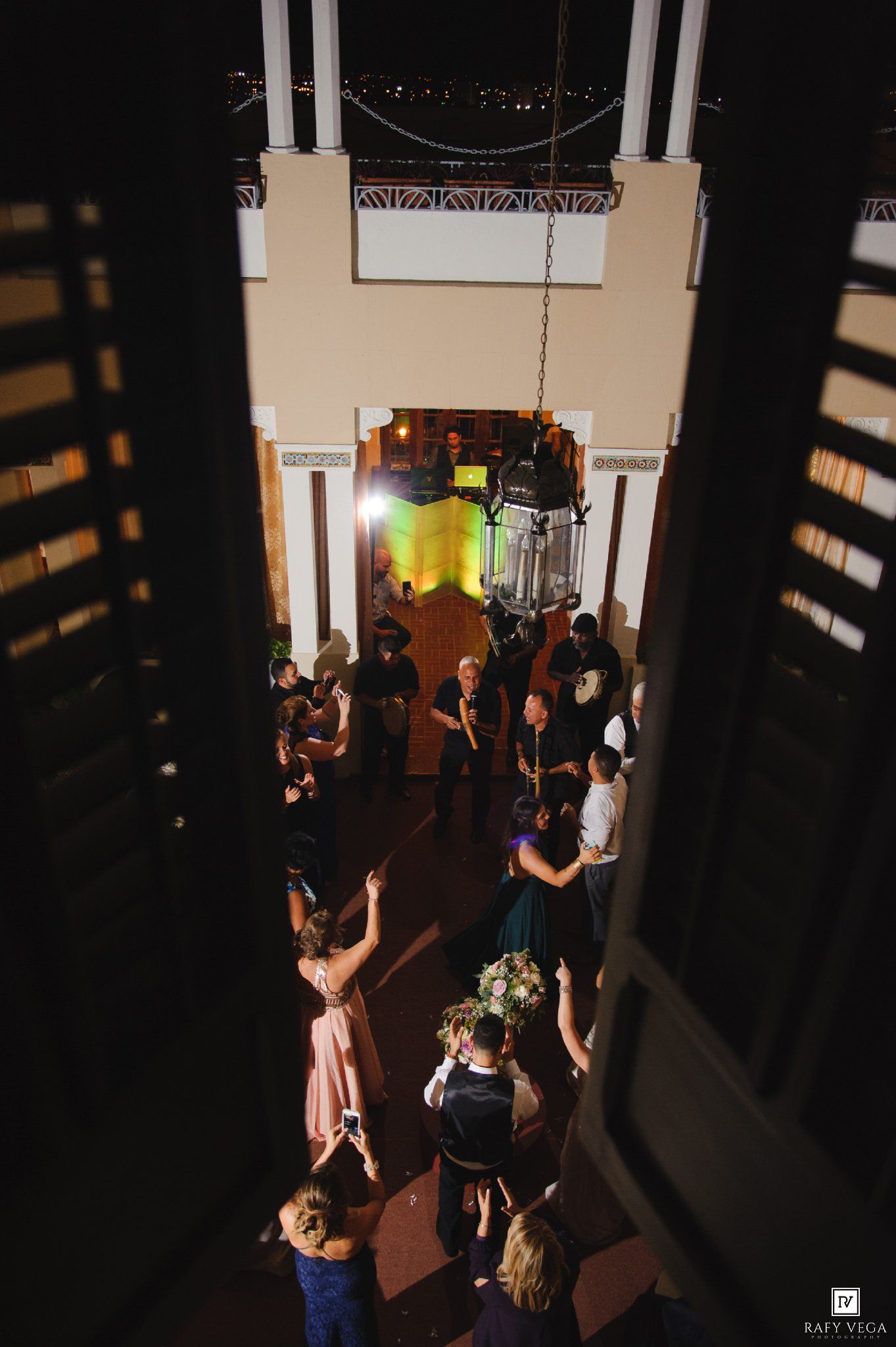 Aerial view of wedding reception dance floor with guests dancing under chandelier.