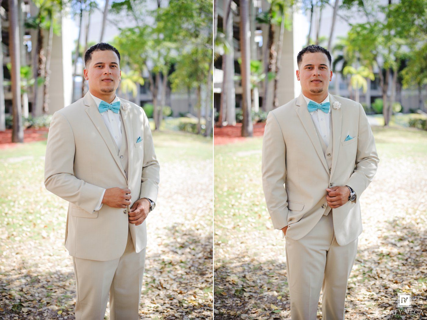 A groom in a beige suit and turquoise bow tie stands outdoors among tall trees on his wedding day.