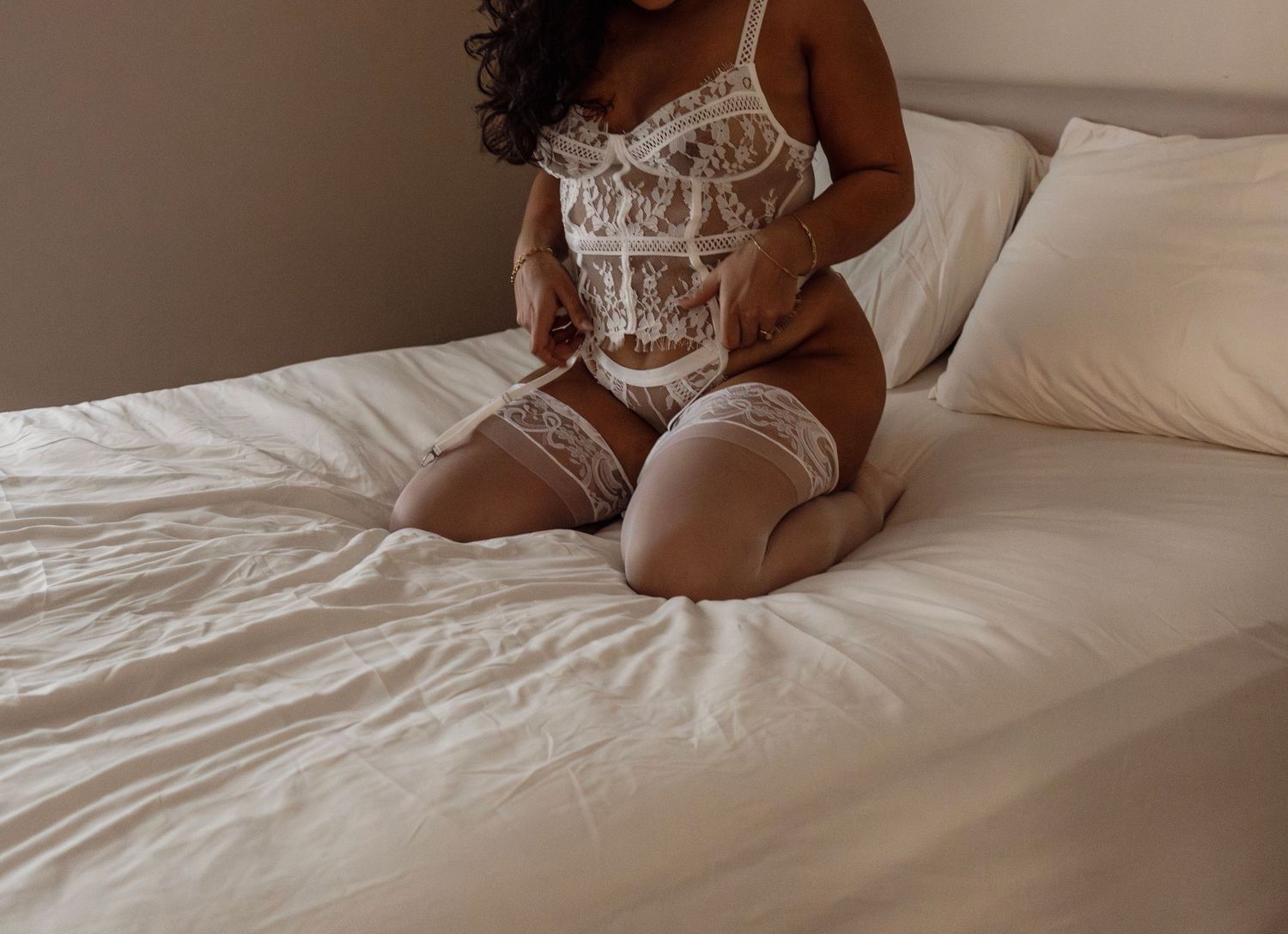 Boudoir photography in New Jersey featuring a woman in soft natural light captured in an intimate bedroom setting with romantic style