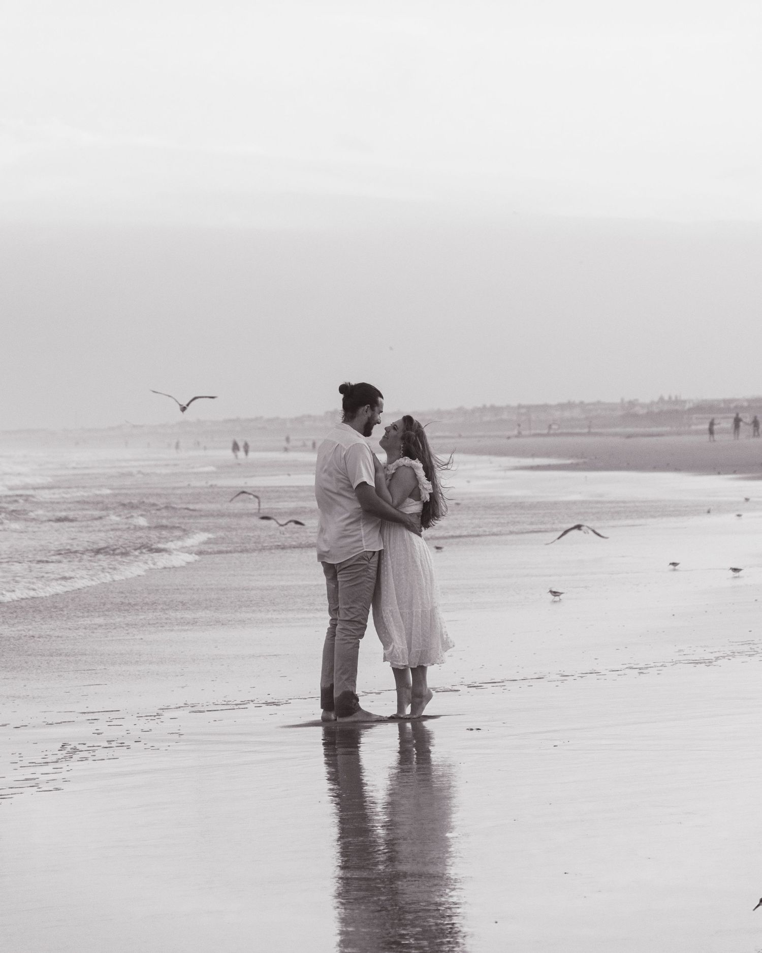 Couple embracing on shoreline during romantic beach session New Jersey
