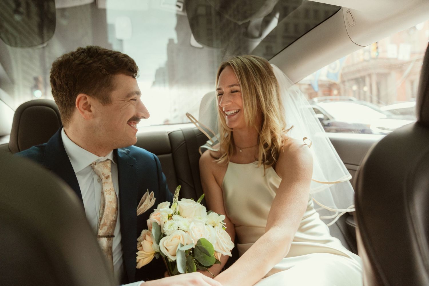 Bride and groom candid moment wedding day Philadelphia city hall photography, back seat of car candid.