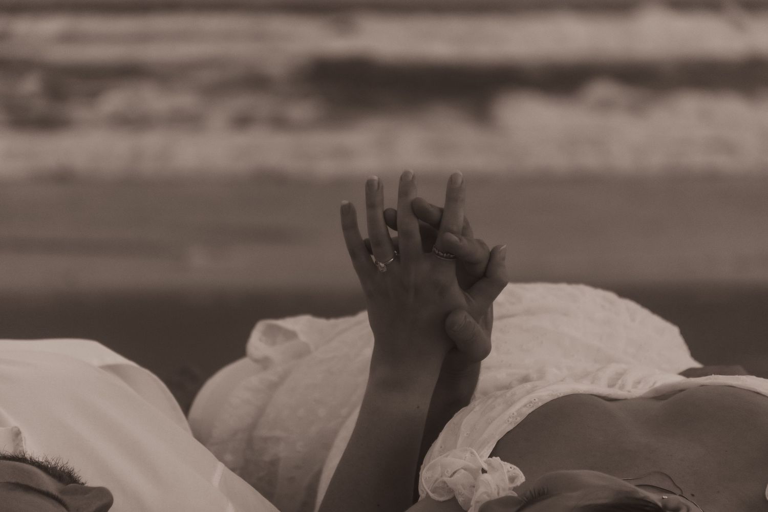 Couple lying on beach together intimate moment soft natural light