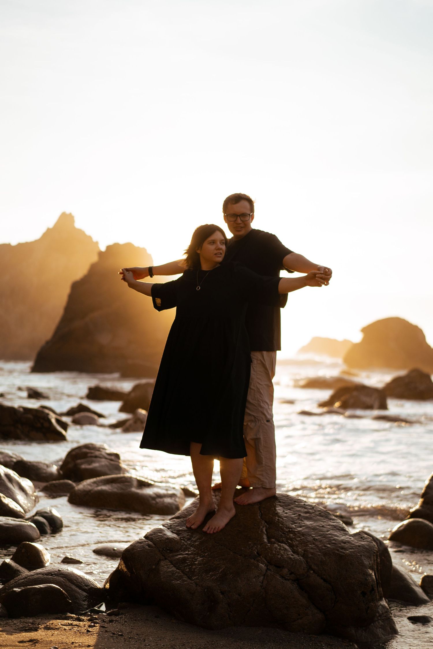 A couple standing on the rocks at Praia da Ursa at sunset during a couples photography session in Portugal