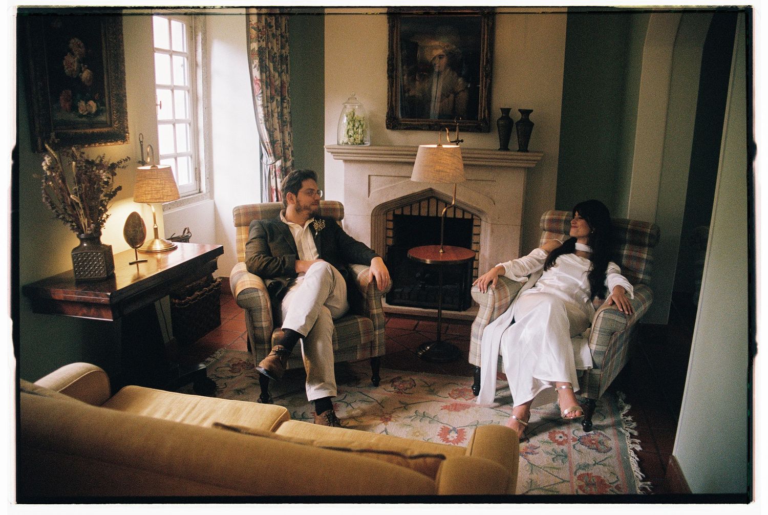 A couple relaxing together in a vintage living room by a fireplace, an intimate elopement at Lawrence's Hotel in Sintra, Portugal