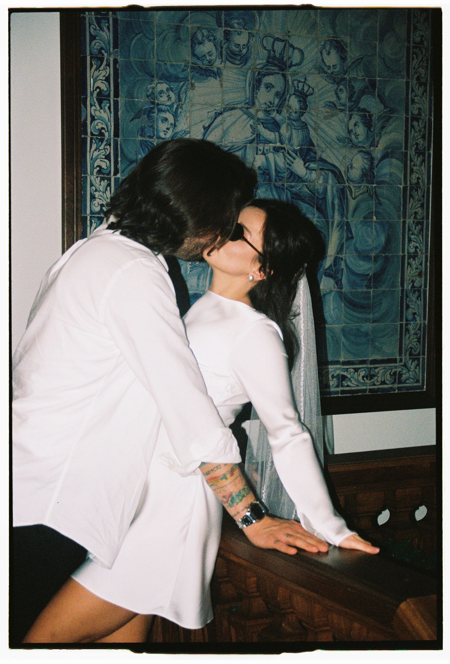 A film photograph of a couple sharing an intimate moment on an ornate staircase during their elopement in Estoril, Portugal