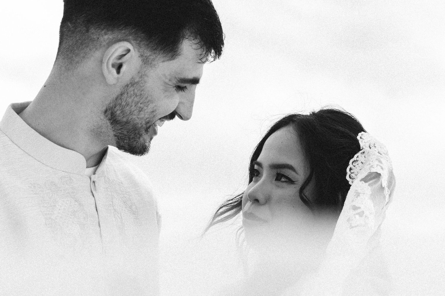 Romantic black and white close-up of a tender moment under fabric canopy at beach wedding, near Porto, Portugal