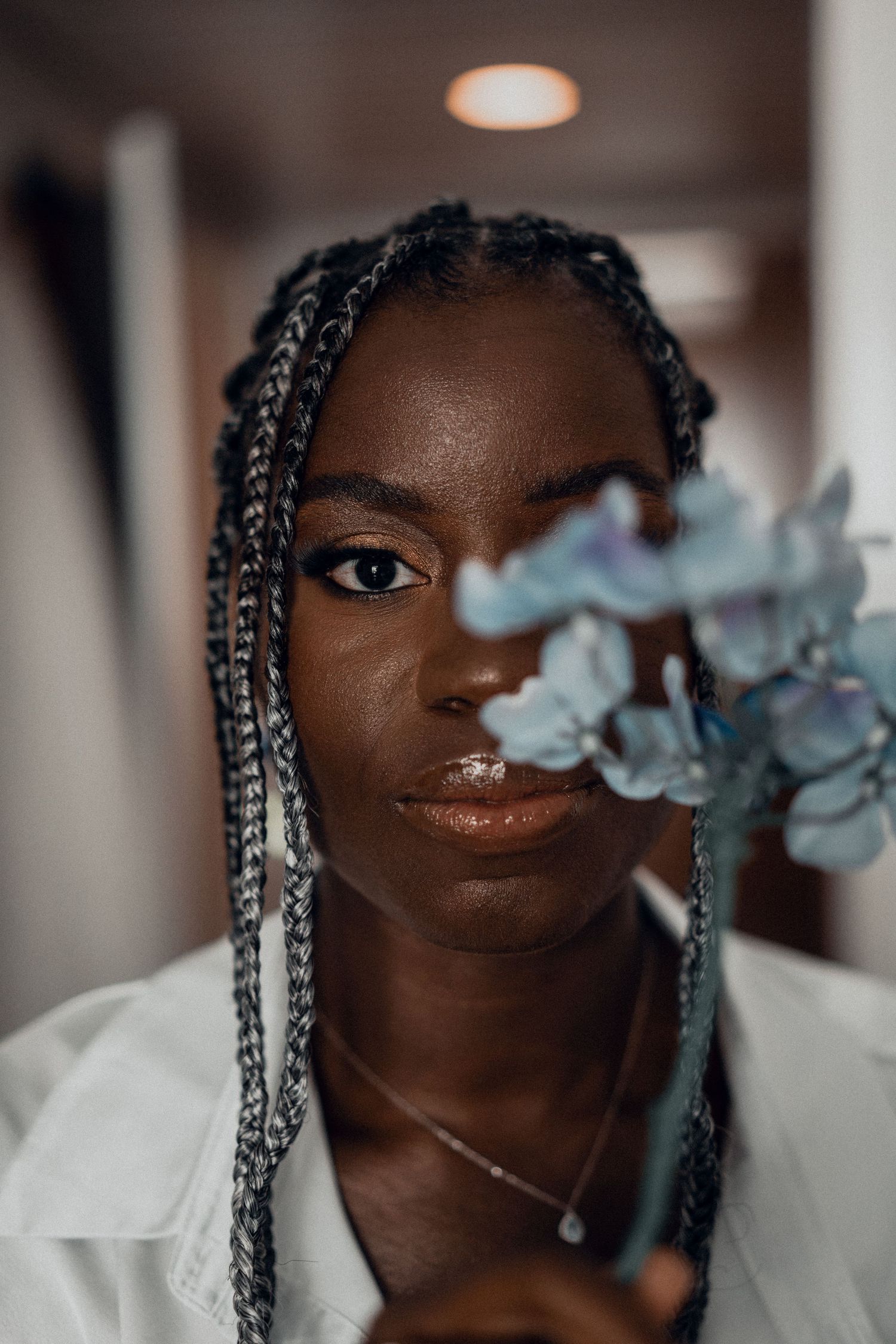 Artistic bridal portrait with blue flowers creating a dreamy atmosphere.