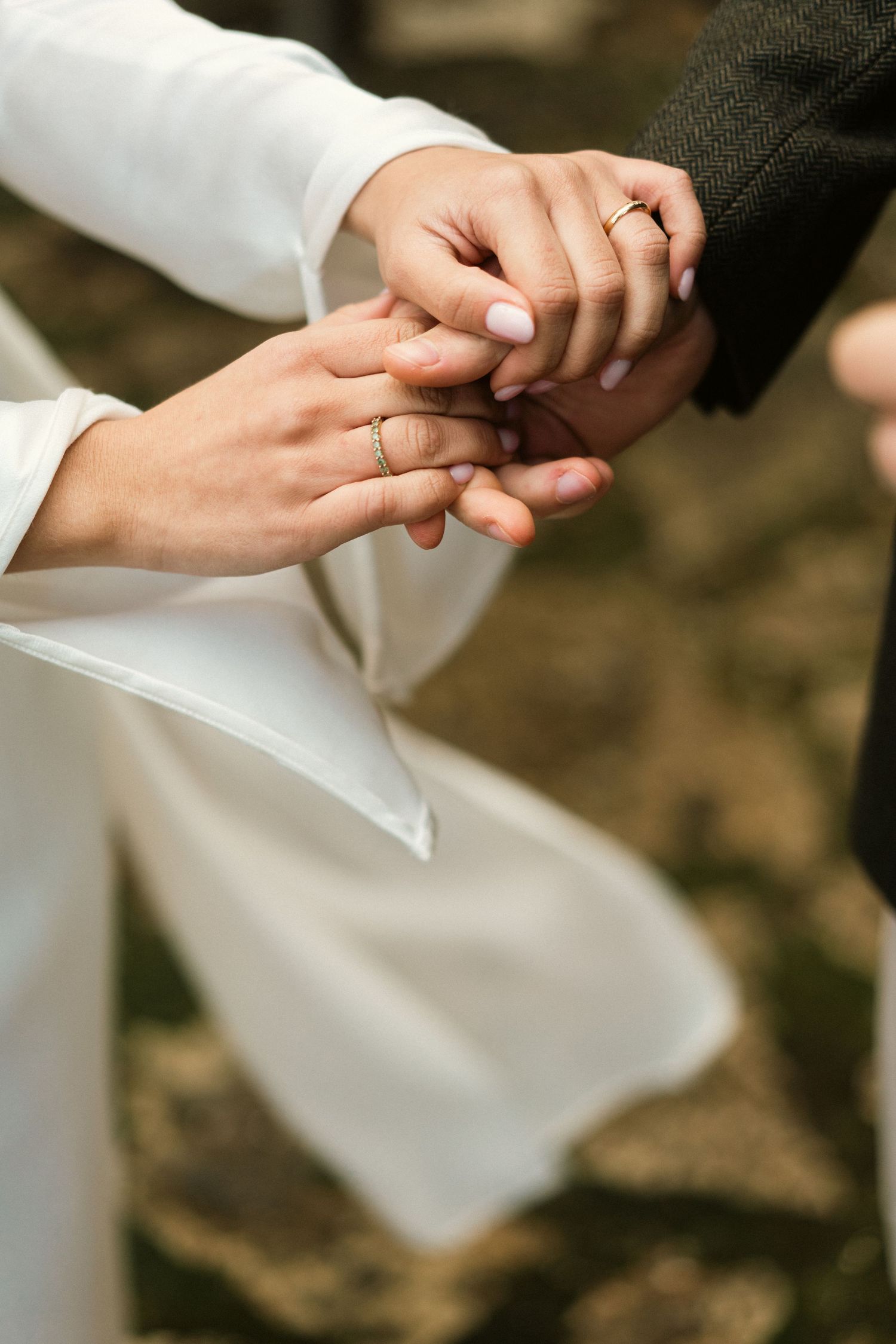 A close-up of a couple holding hands with wedding rings during their elopement in Portugal
